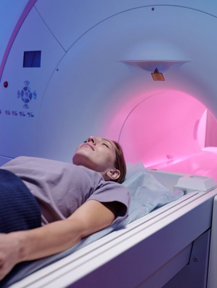Young female lying on table of mri scan equipment